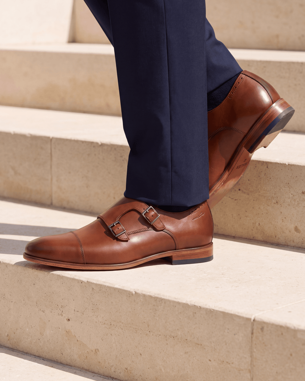 Cognac gladleren Rhodes gespschoen – close-up van het paar op kalksteen