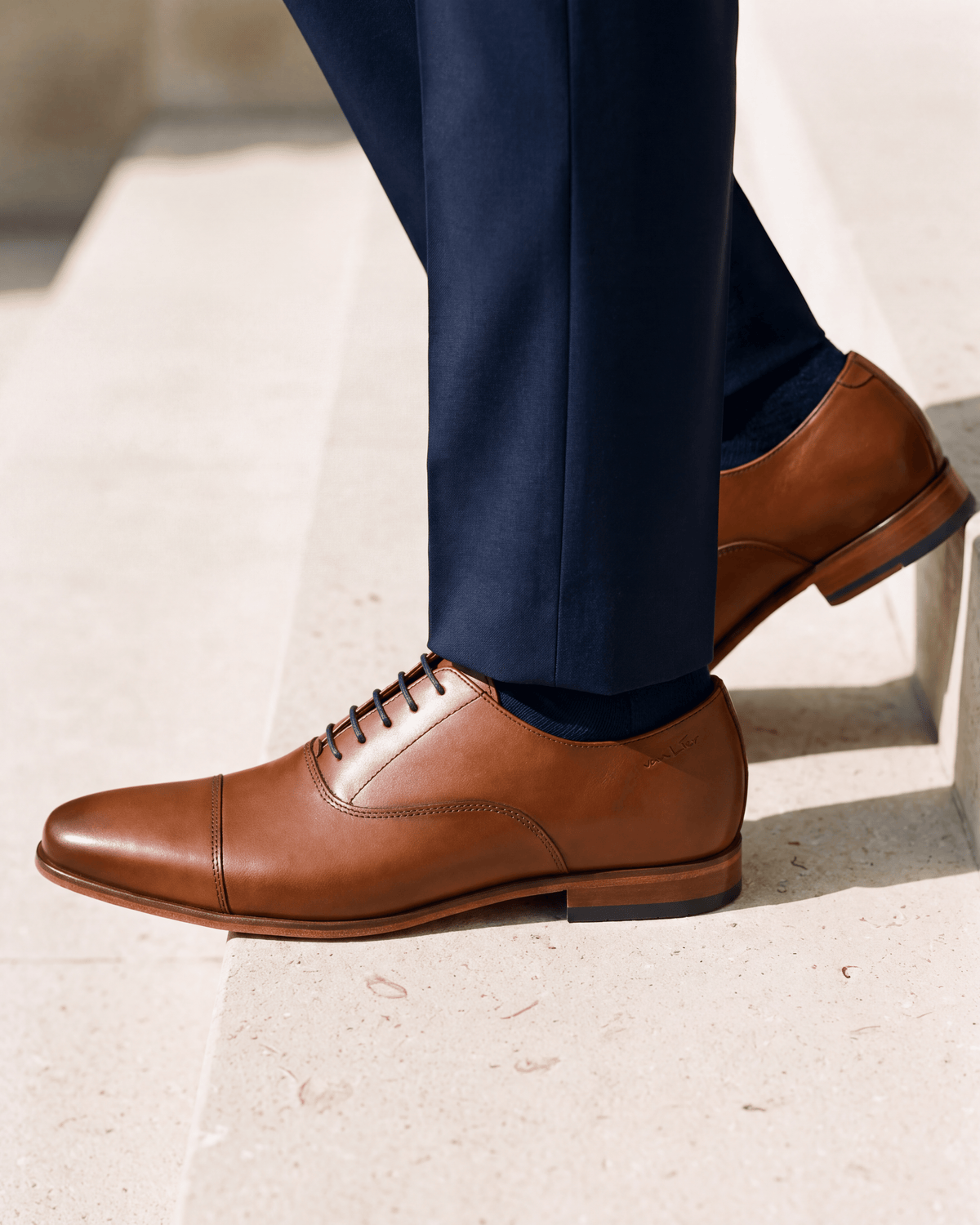 Cognac gladleren Rhodes veterschoen – close-up van het paar op kalksteen