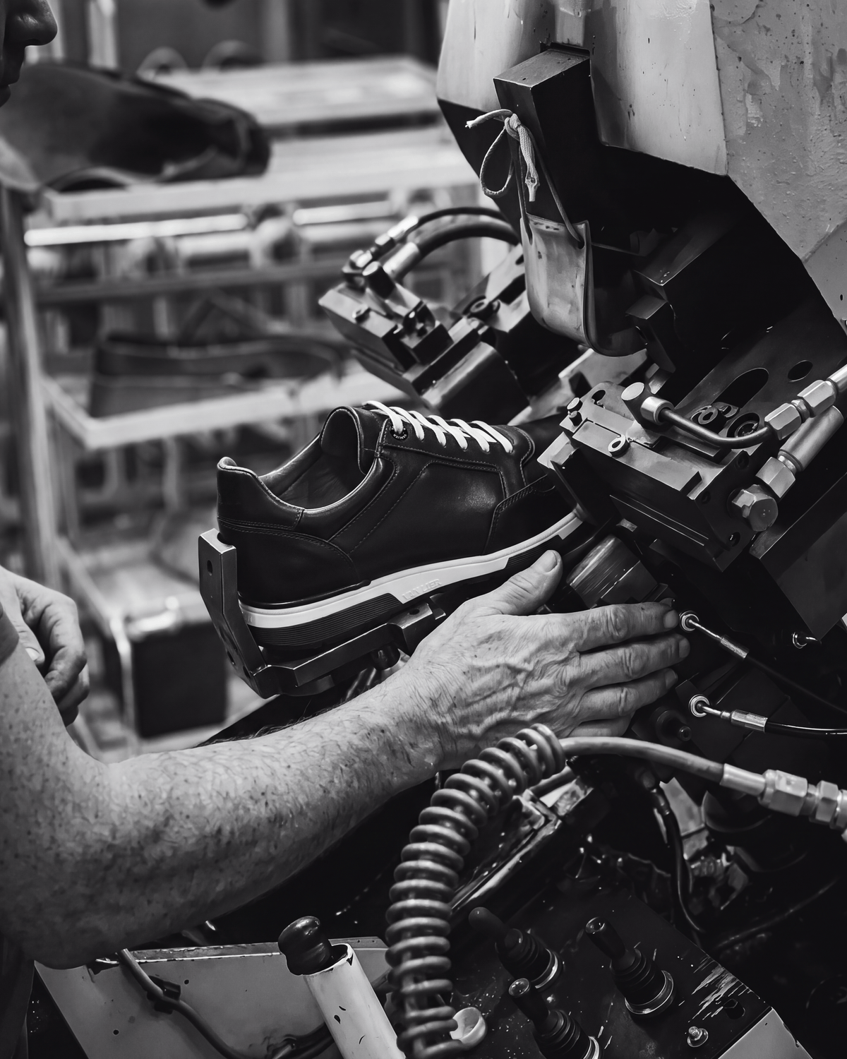 Zwart gladleren Positano sneaker – zwart-wit foto van het ambachtelijke productieproces