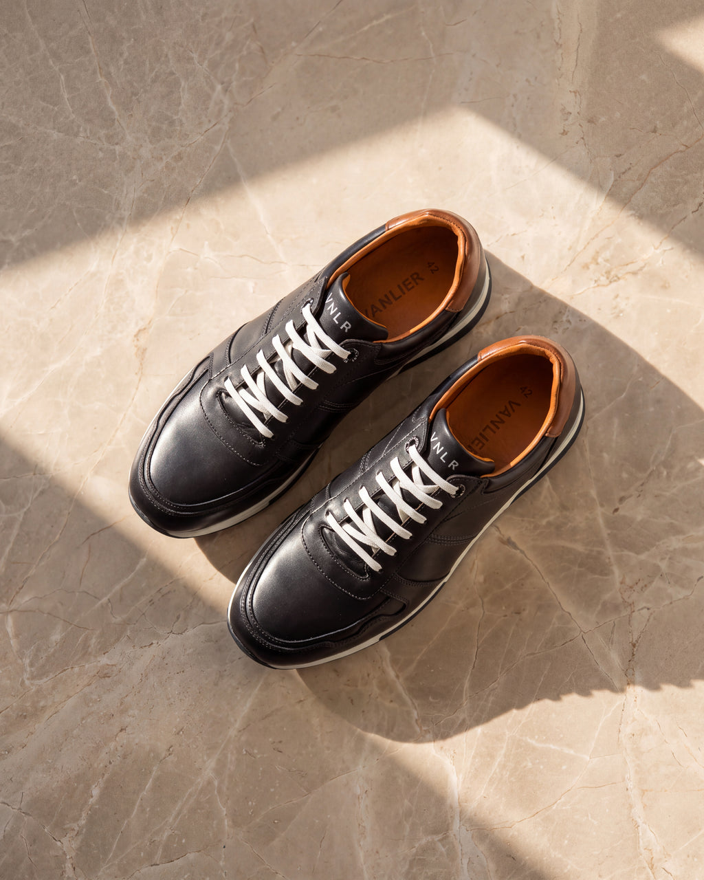 Donker Blauw gladleren Positano sneaker – detail van het paar op marmer