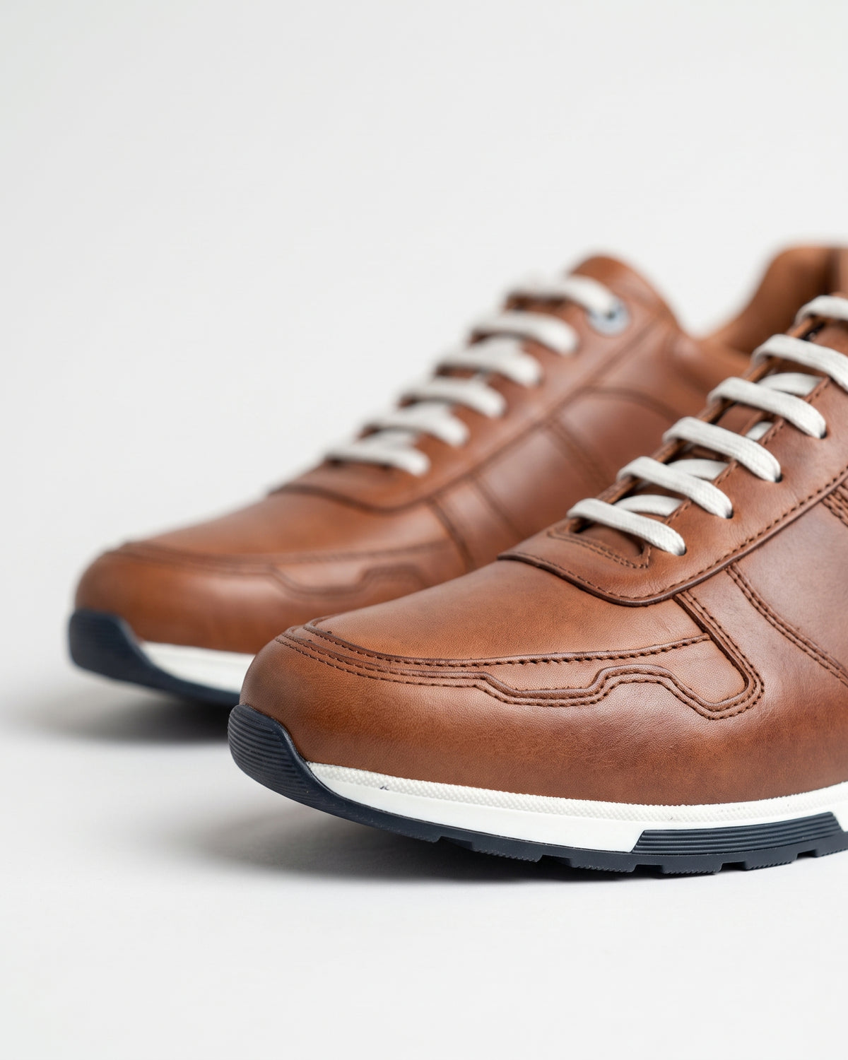 Cognac gladleren Positano sneaker – macro-detail van de afwerking