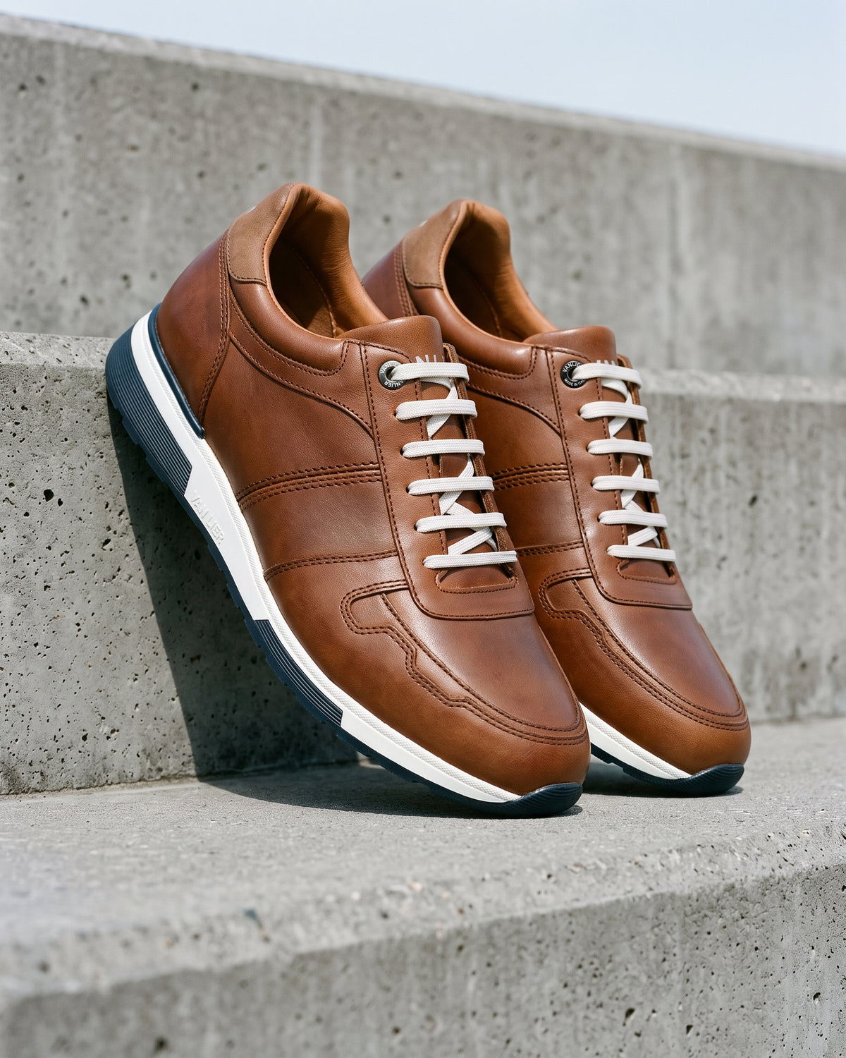 Cognac gladleren Positano sneaker – paar op ruw beton