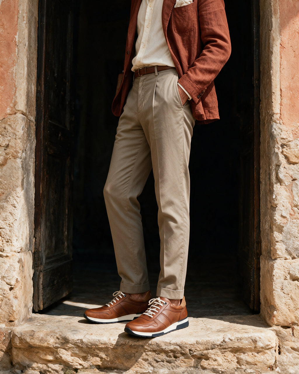 Cognac gladleren Positano sneaker – gedragen bij een deuropening in de zon