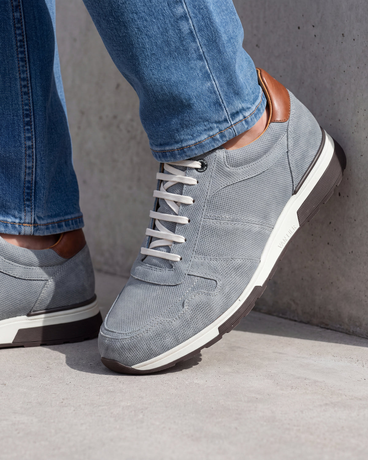 Grijs blauw suède Positano sneaker – close-up van het paar op een ruwe betonnen vloer