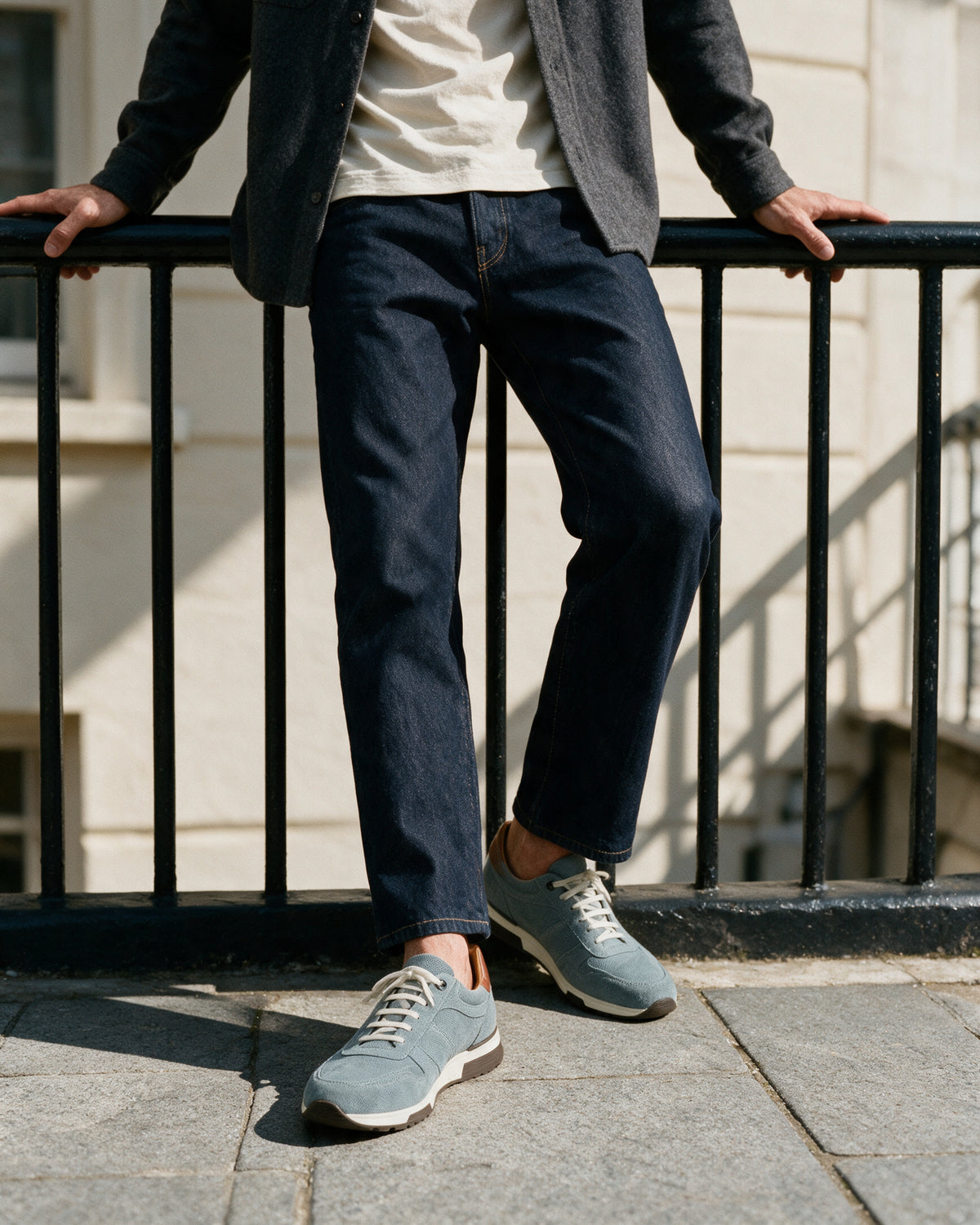 Grijs blauw suède Positano sneaker – lifestyle met de voet op de reling