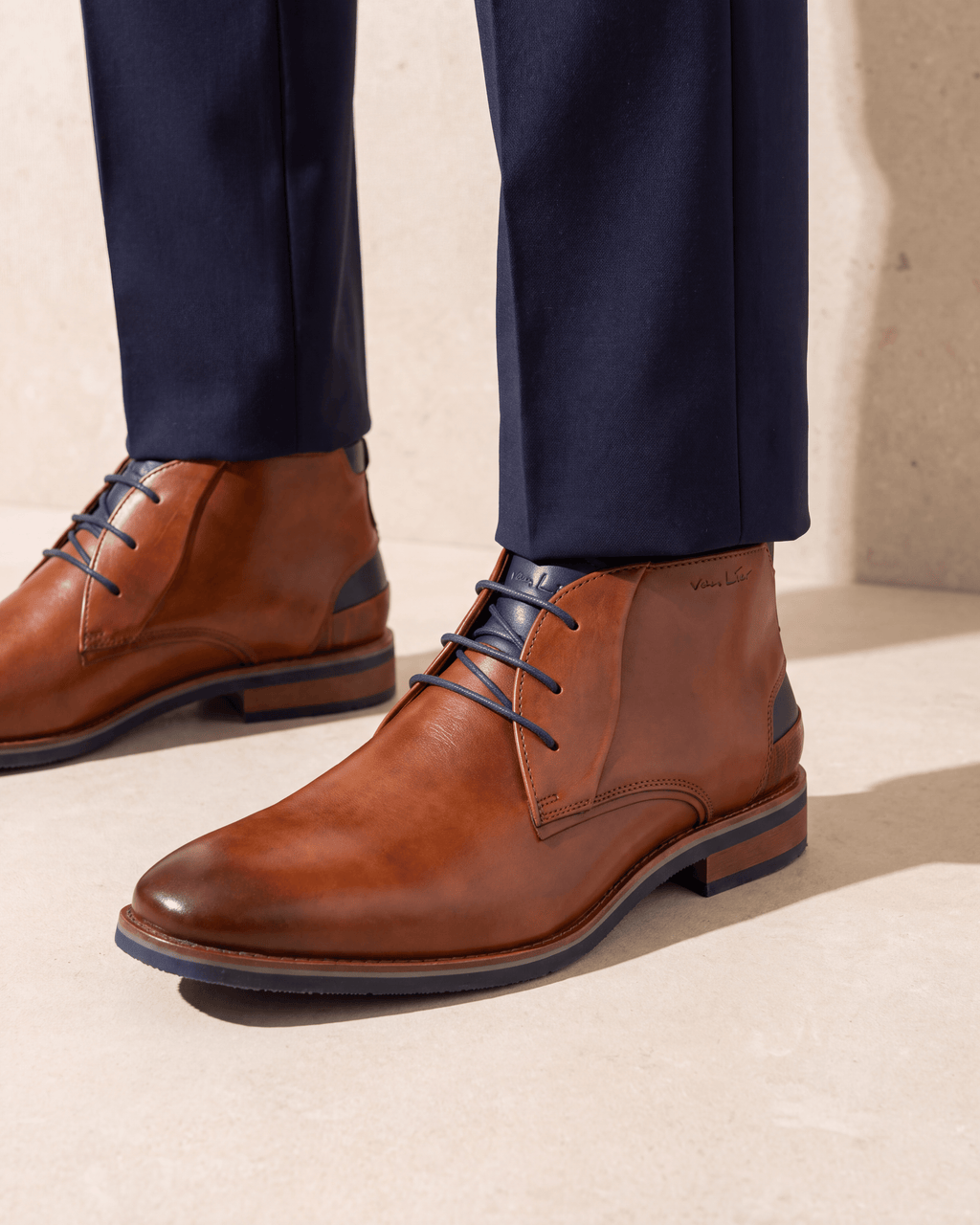 Cognac gladleren Amalfi halfhoge veterschoen – het paar op een kalkstenen vloer
