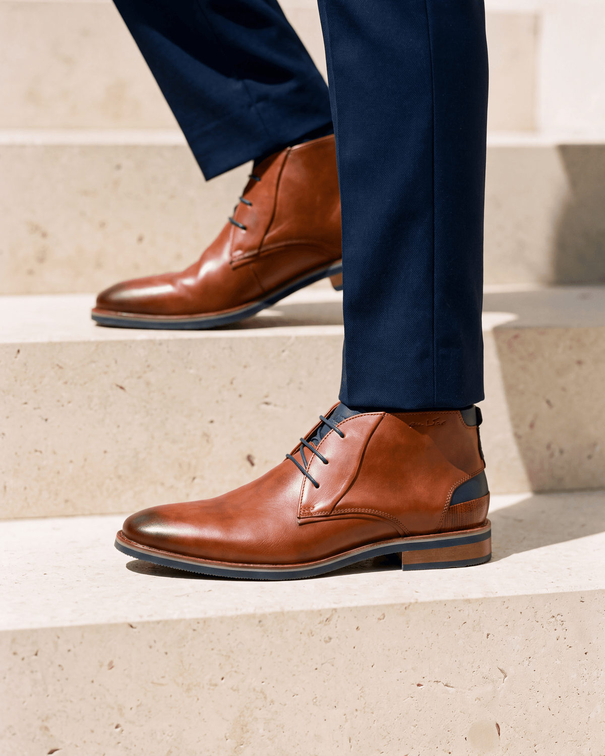 Cognac gladleren Amalfi halfhoge veterschoen – close-up van het paar op kalksteen