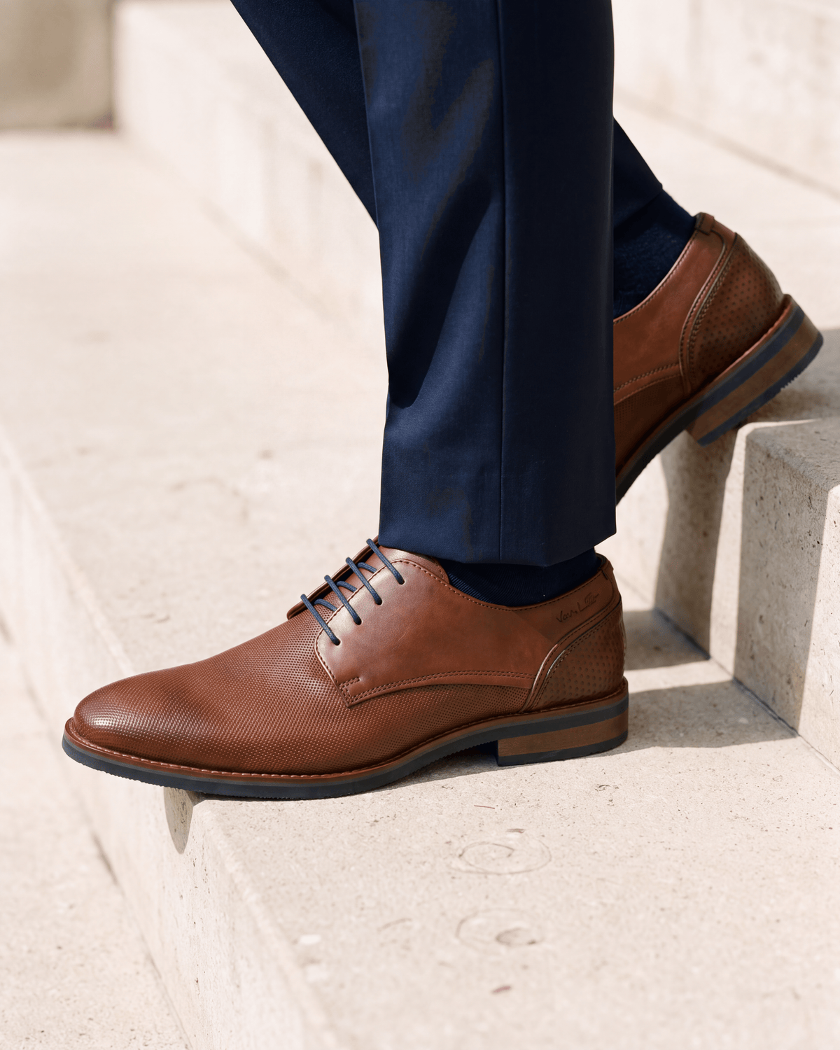 Licht cognac gladleren Amalfi veterschoen – het paar op een kalkstenen vloer