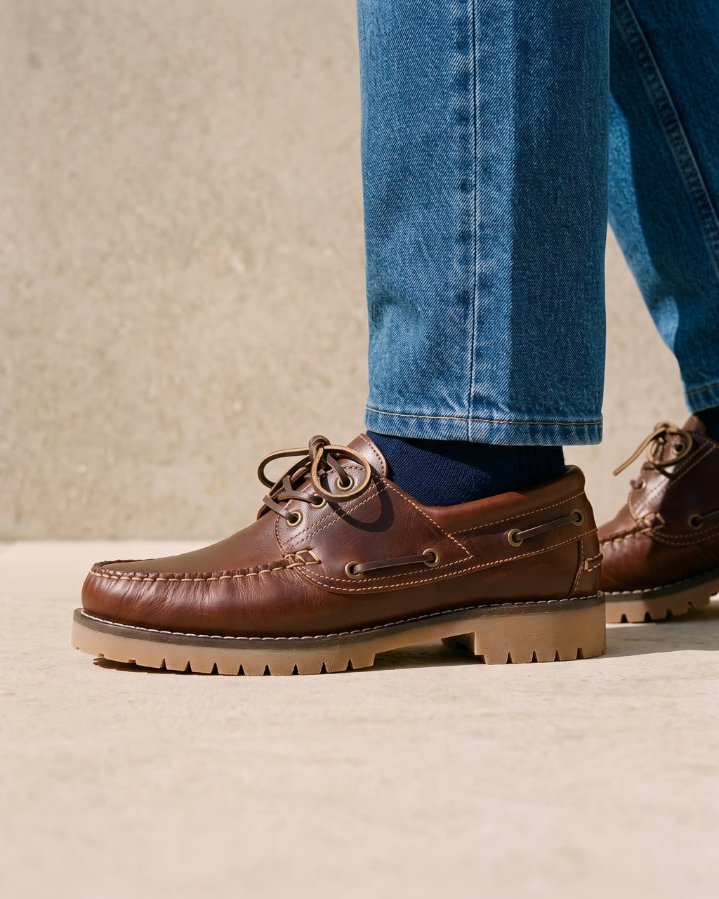 Bruin gladleren Baylands boot – close-up van het paar op een kalkstenen vloer