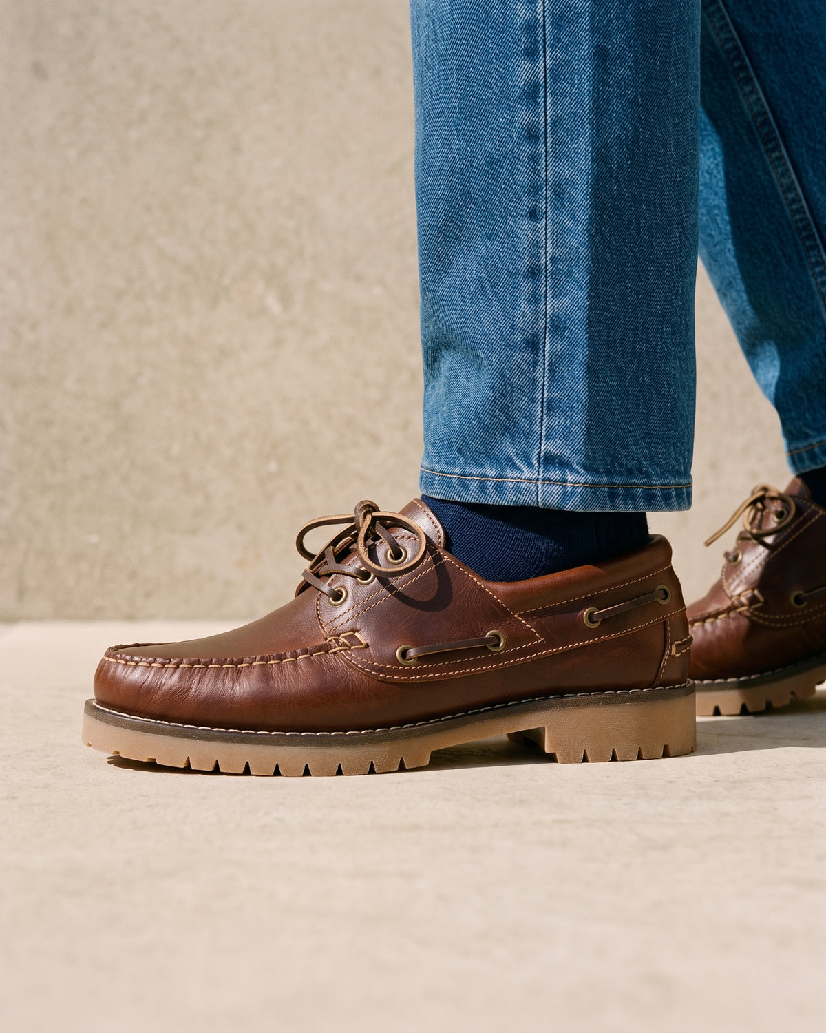 Bruin gladleren Baylands boot – close-up van het paar op een kalkstenen vloer