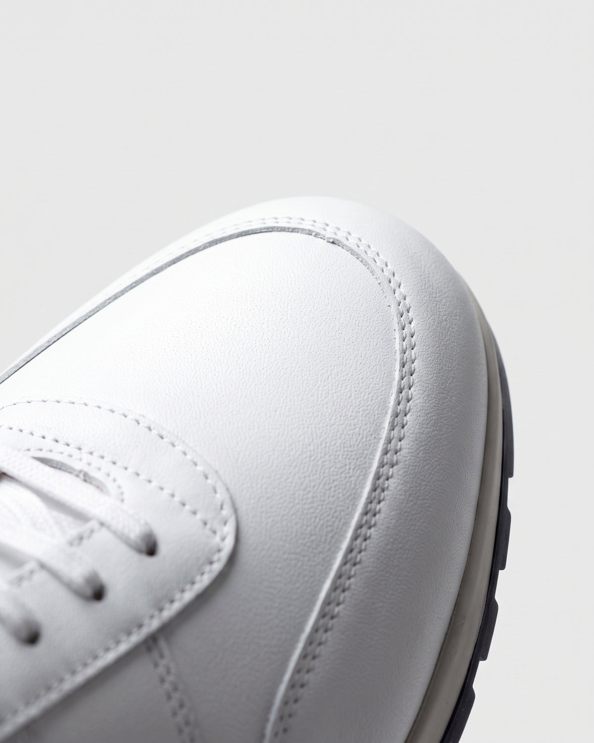 Wit gladleren Anzano sneaker – macro-detail van het paar