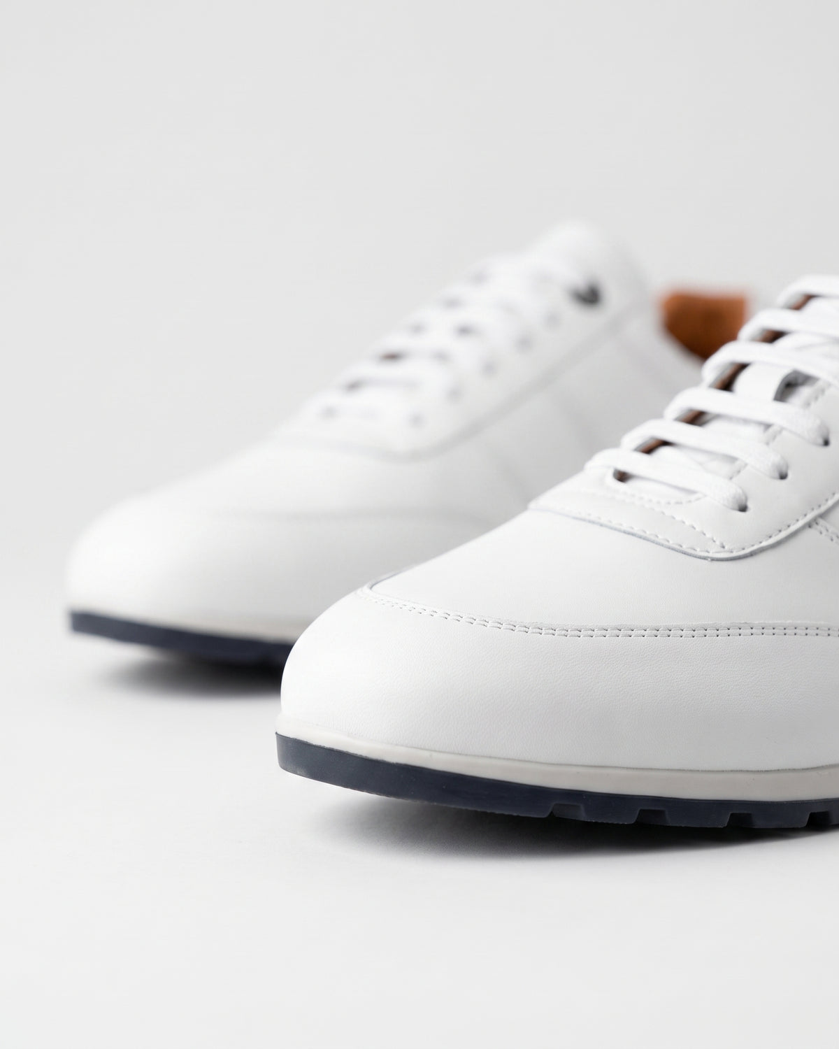 Wit gladleren Anzano sneaker – macro-detail van het paar
