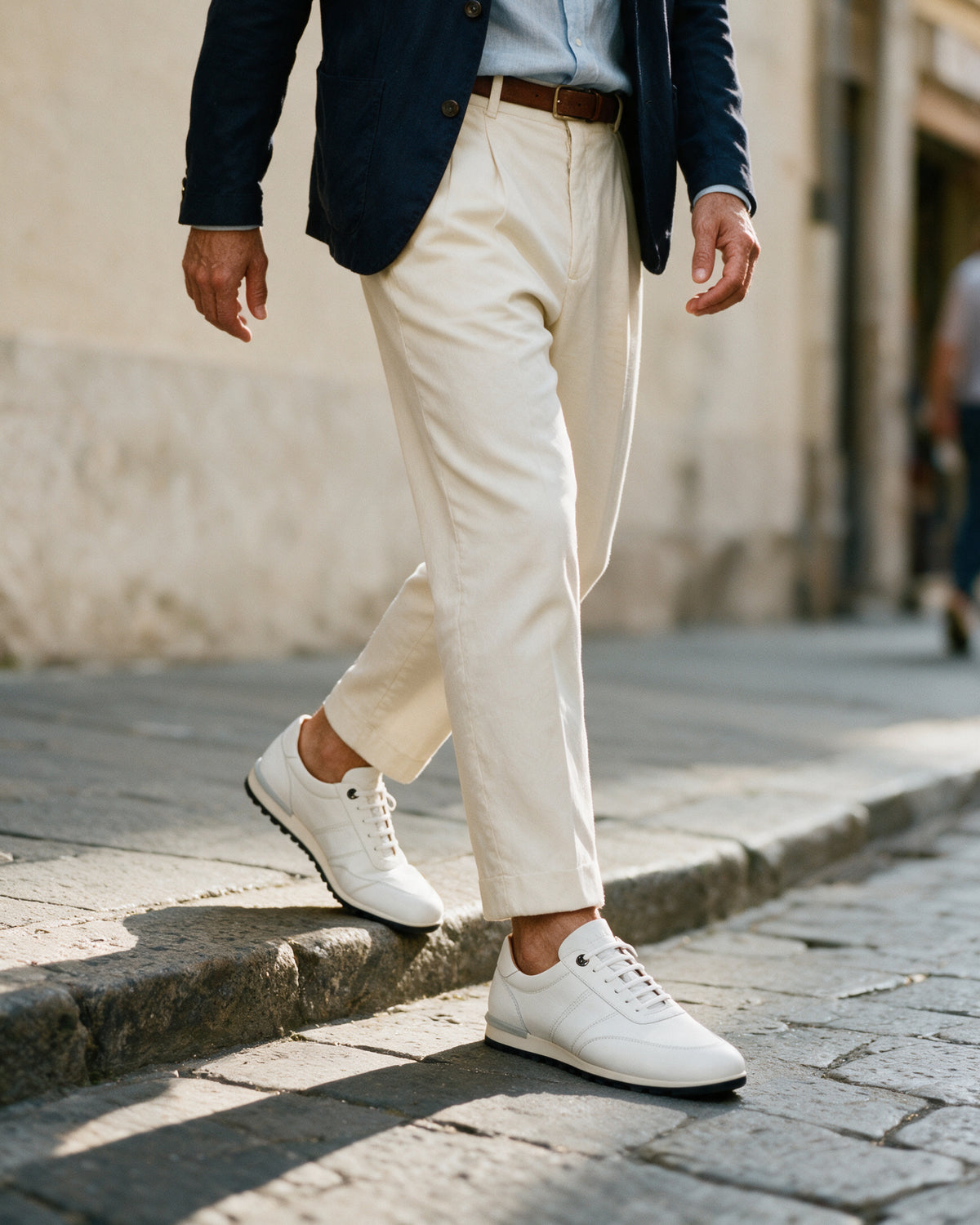 Wit gladleren Anzano sneaker – gedragen bij het afstappen van het verhoogde trottoir