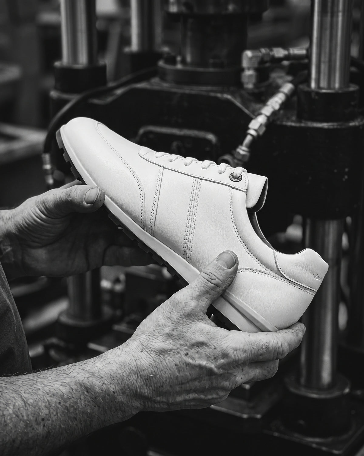 Wit gladleren Anzano sneaker – zwart-wit foto van het ambachtelijke productieproces