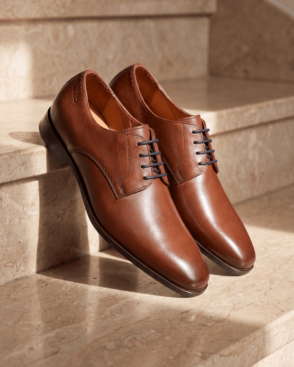 Cognac gladleren Santorini veterschoen – close-up op warm marmer