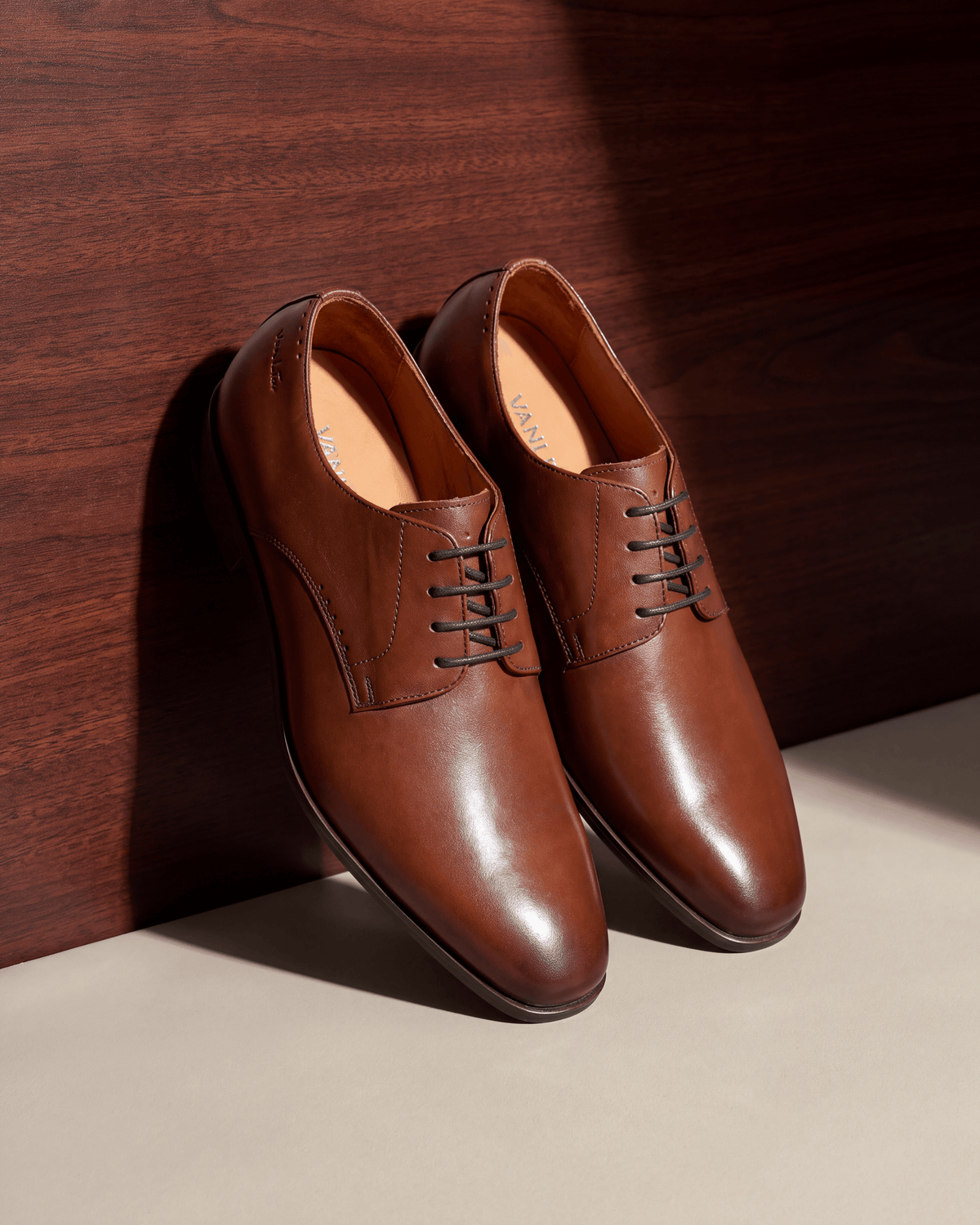Cognac gladleren Santorini veterschoen – het paar op hout en pleisterwerk