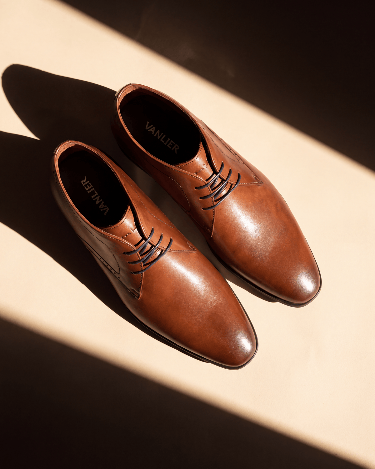 Cognac gladleren Portofino halfhoge veterschoen – detail bij een raam met schaduw