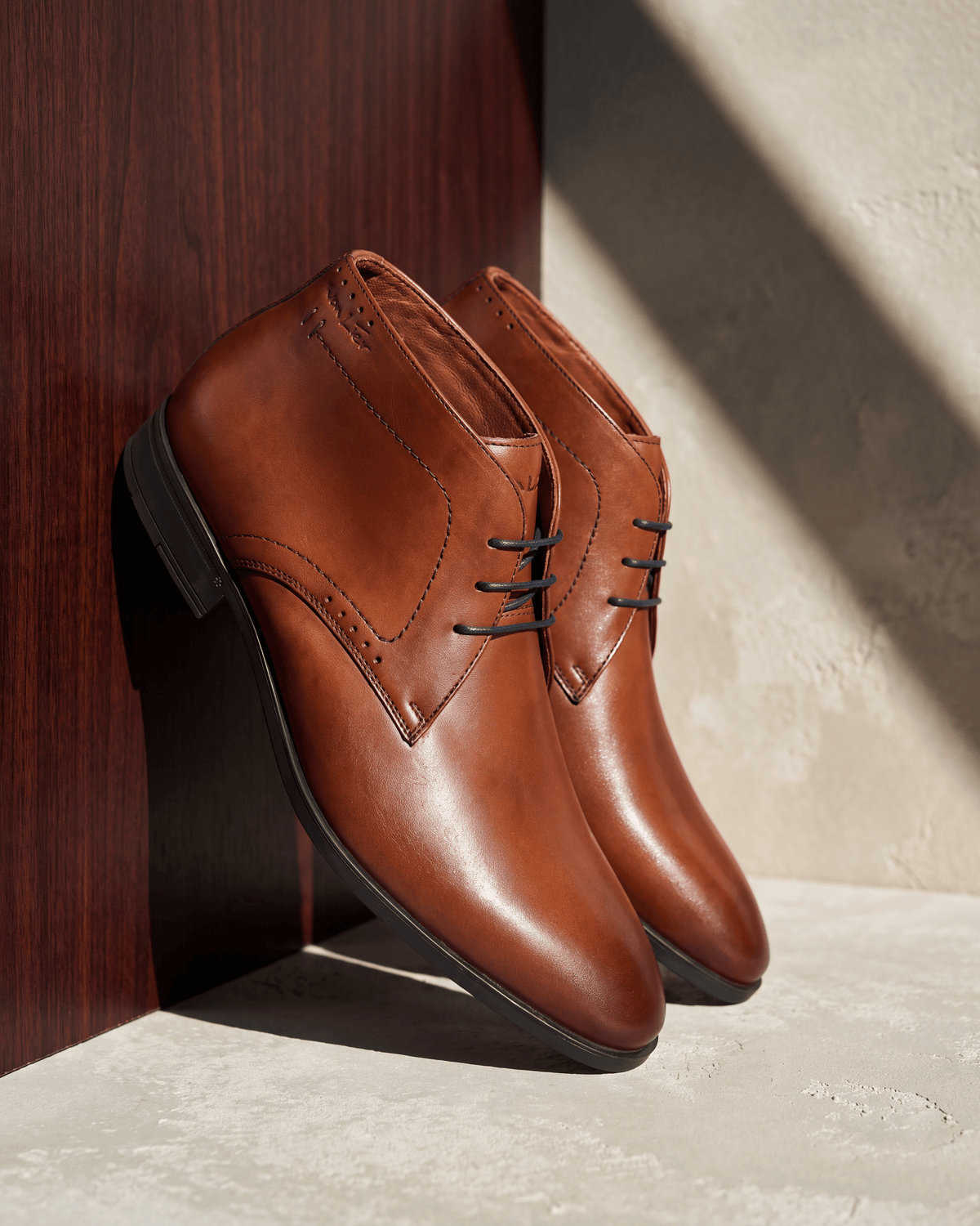Cognac gladleren Portofino halfhoge veterschoen – detail op hout en pleisterwerk
