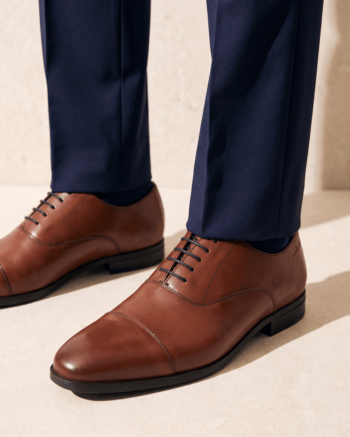 Cognac gladleren Portofino veterschoen – close-up van het paar op kalksteen