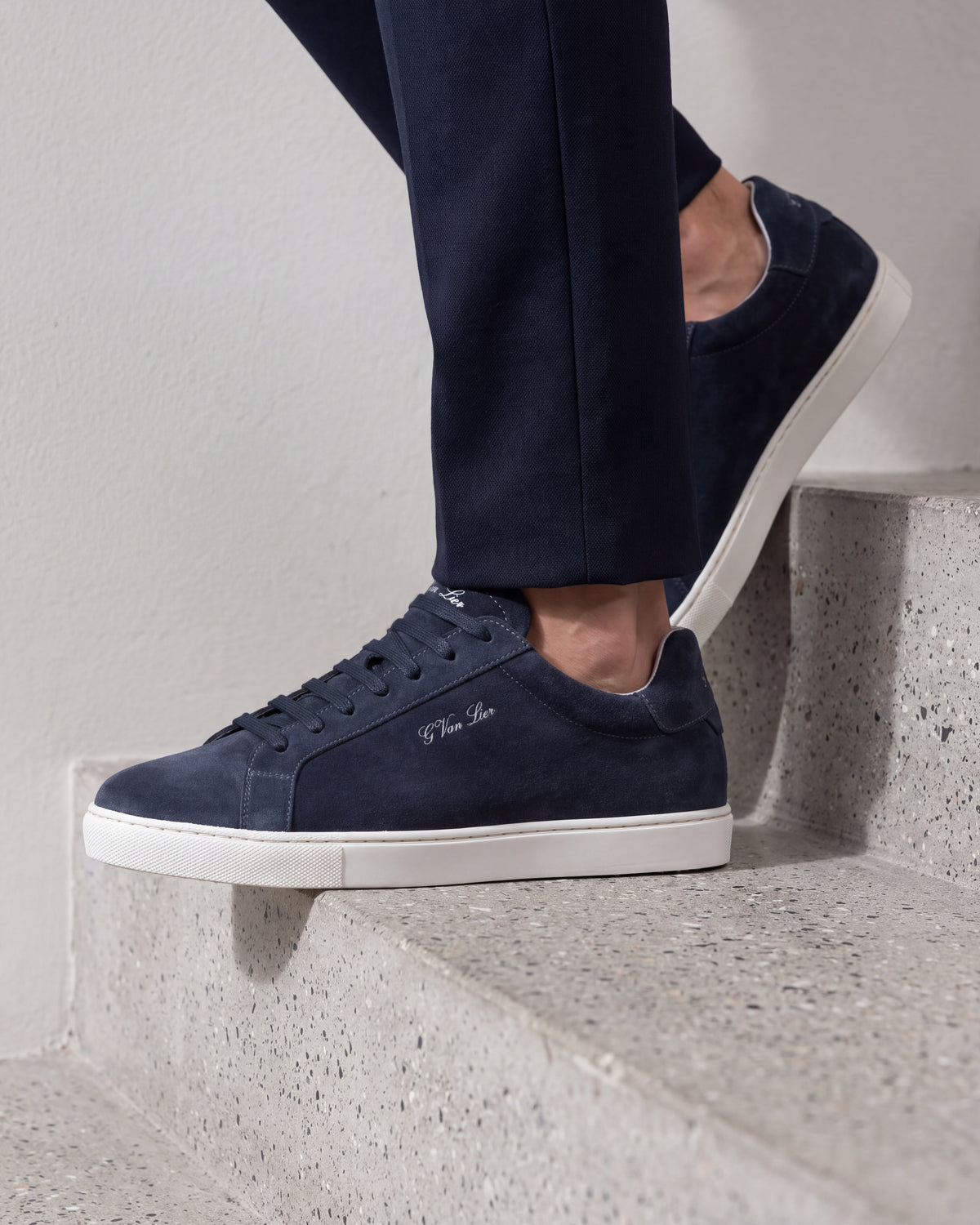 Navy blauw suède Napoli sneaker – detail van het paar op beton in een atelier