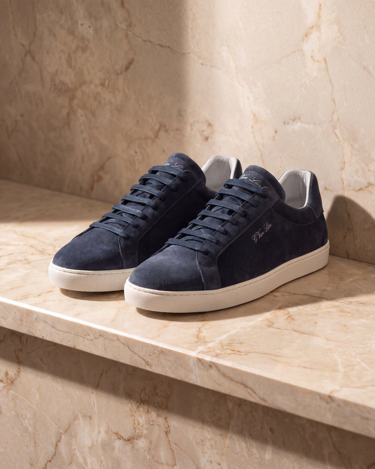 Navy blauw suède Napoli sneaker – close-up van het paar op marmer
