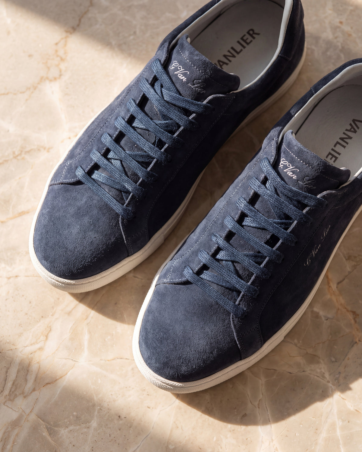Navy blauw suède Napoli sneaker – detail van het paar op marmer