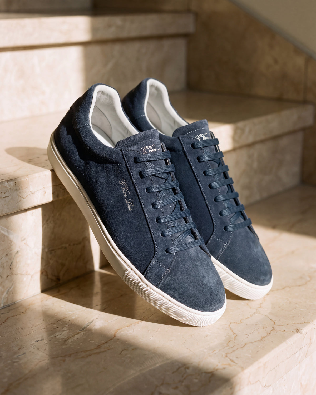 Navy blauw suède Napoli sneaker – close-up van het paar op marmer, andere hoek