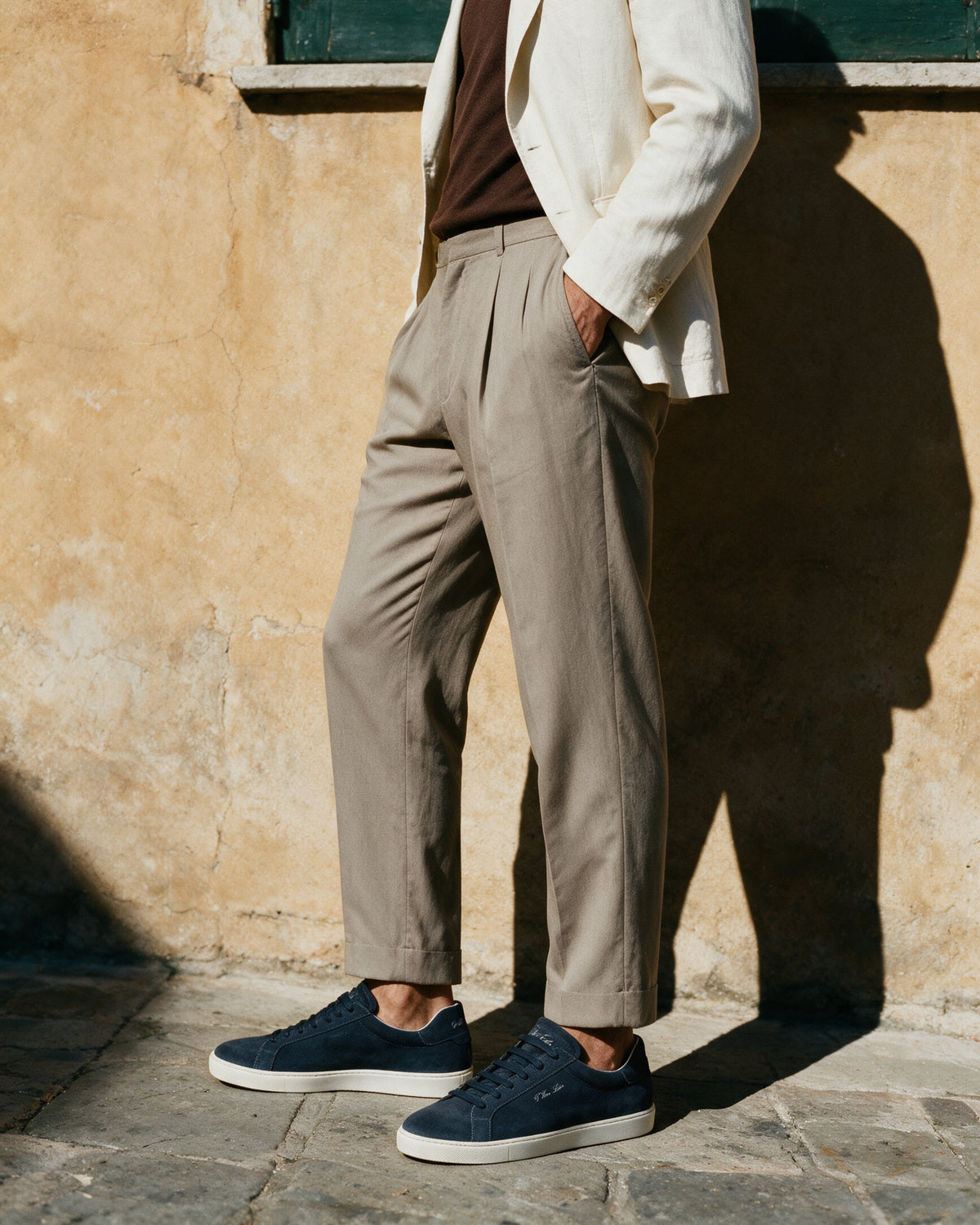 Navy blauw suède Napoli sneaker – lifestyle in profiel bij een okerkleurige muur