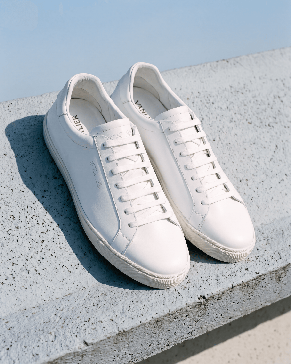Wit gladleren Napoli sneaker – het paar op ruw beton