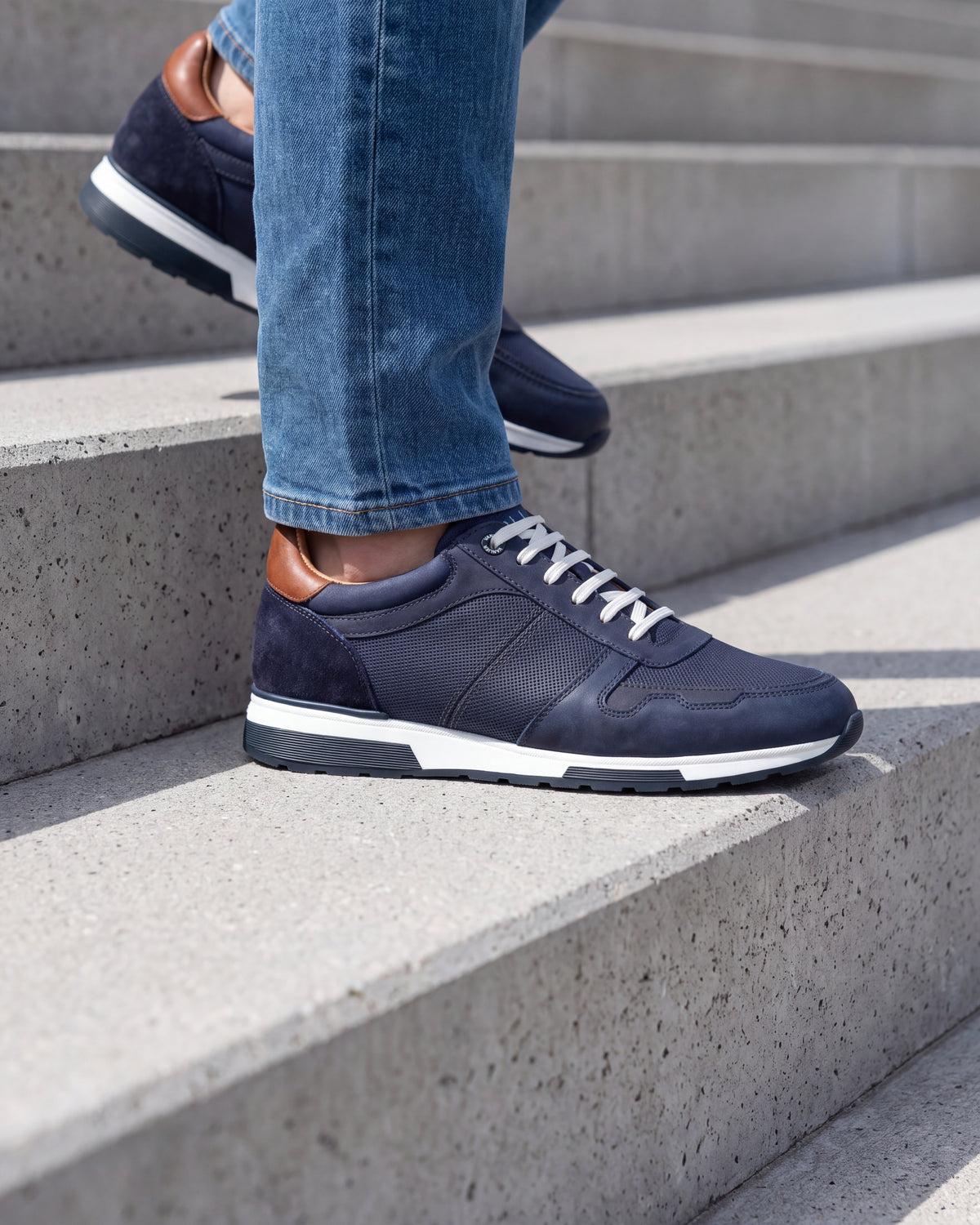 Navy blauw nubuck Positano sneaker – close-up van het paar op een betonnen vloer
