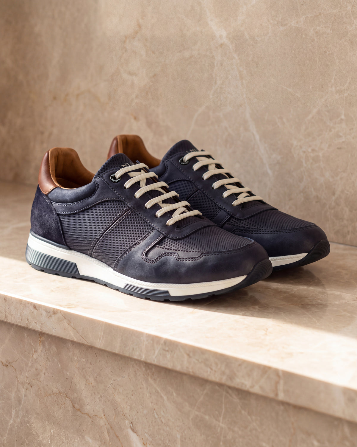 Navy blauw nubuck Positano sneaker – close-up van het paar op marmer