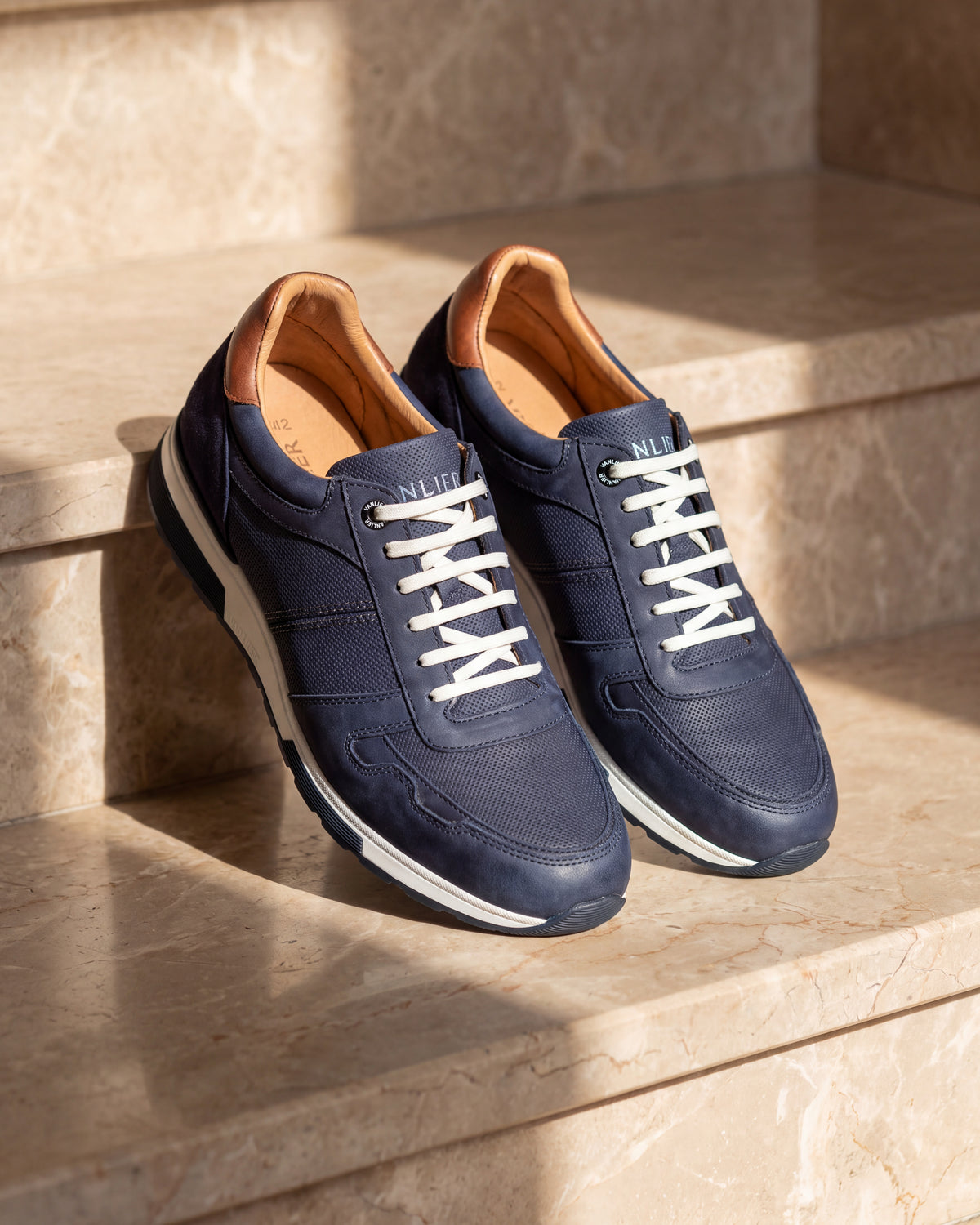 Navy blauw nubuck Positano sneaker – close-up van het paar op marmer, andere hoek