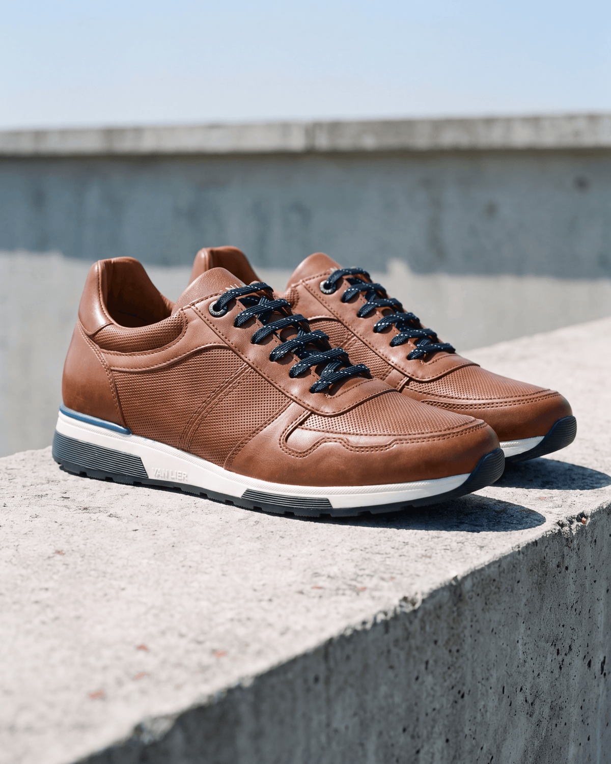 Cognac gladleren Positano sneaker – het paar op ruw beton