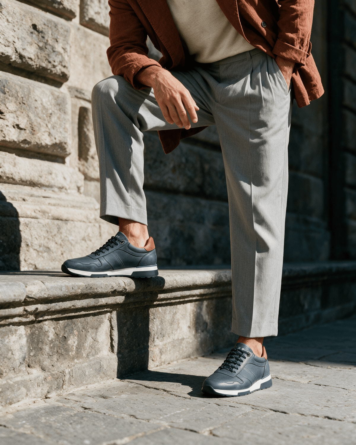 Navy blauw gladleren Positano sneaker – gedragen, met een voet op een sokkel