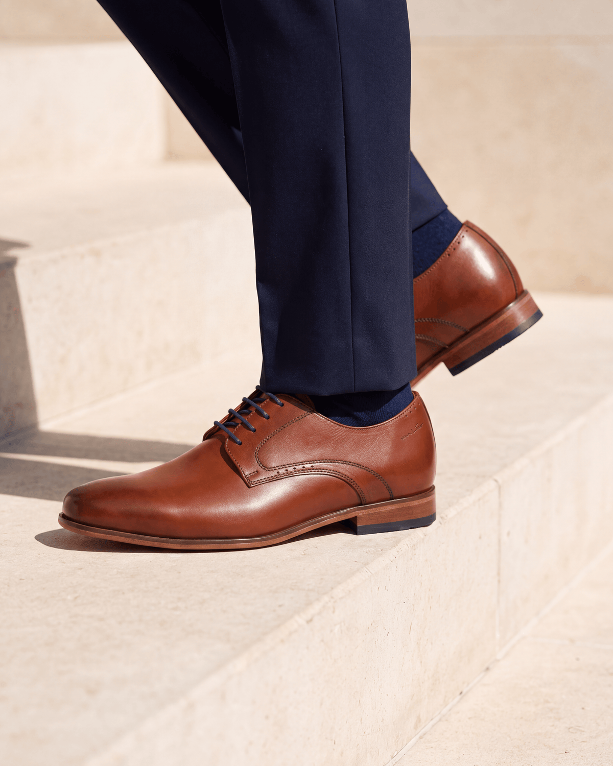 Cognac gladleren Rhodes veterschoen – close-up van het paar op kalksteen