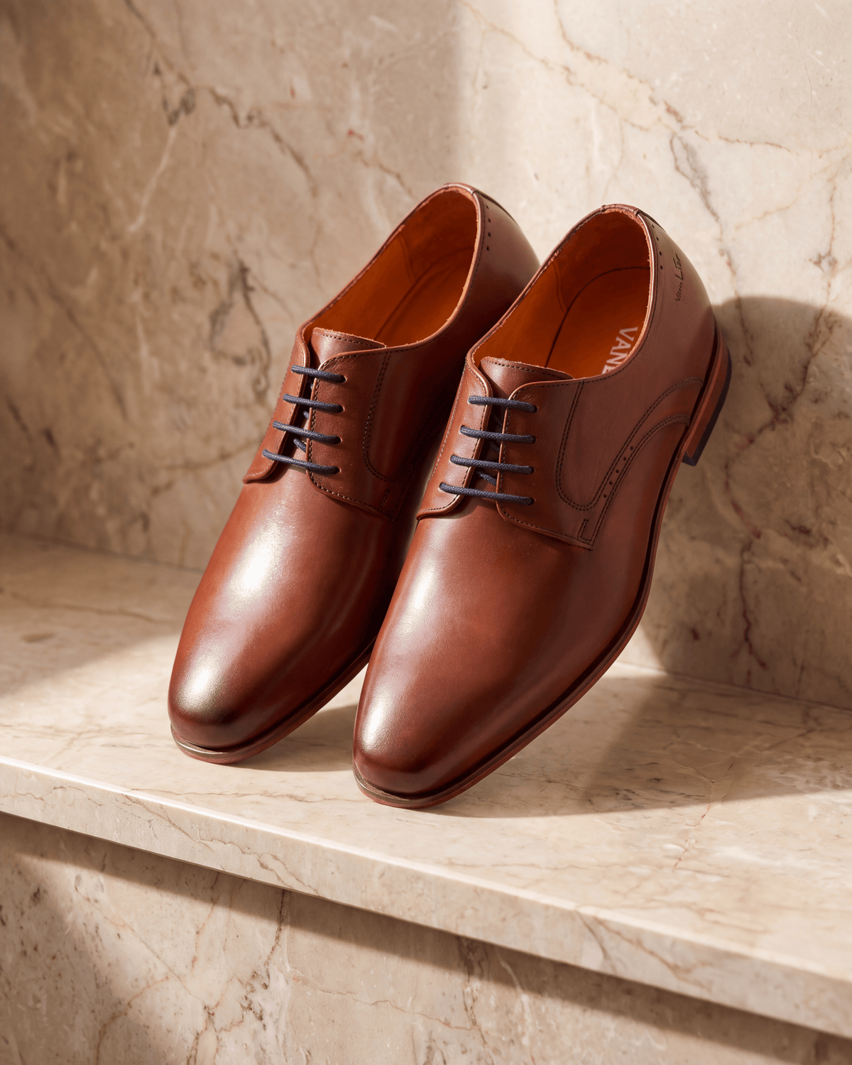 Cognac gladleren Rhodes veterschoen – het paar op warm marmer