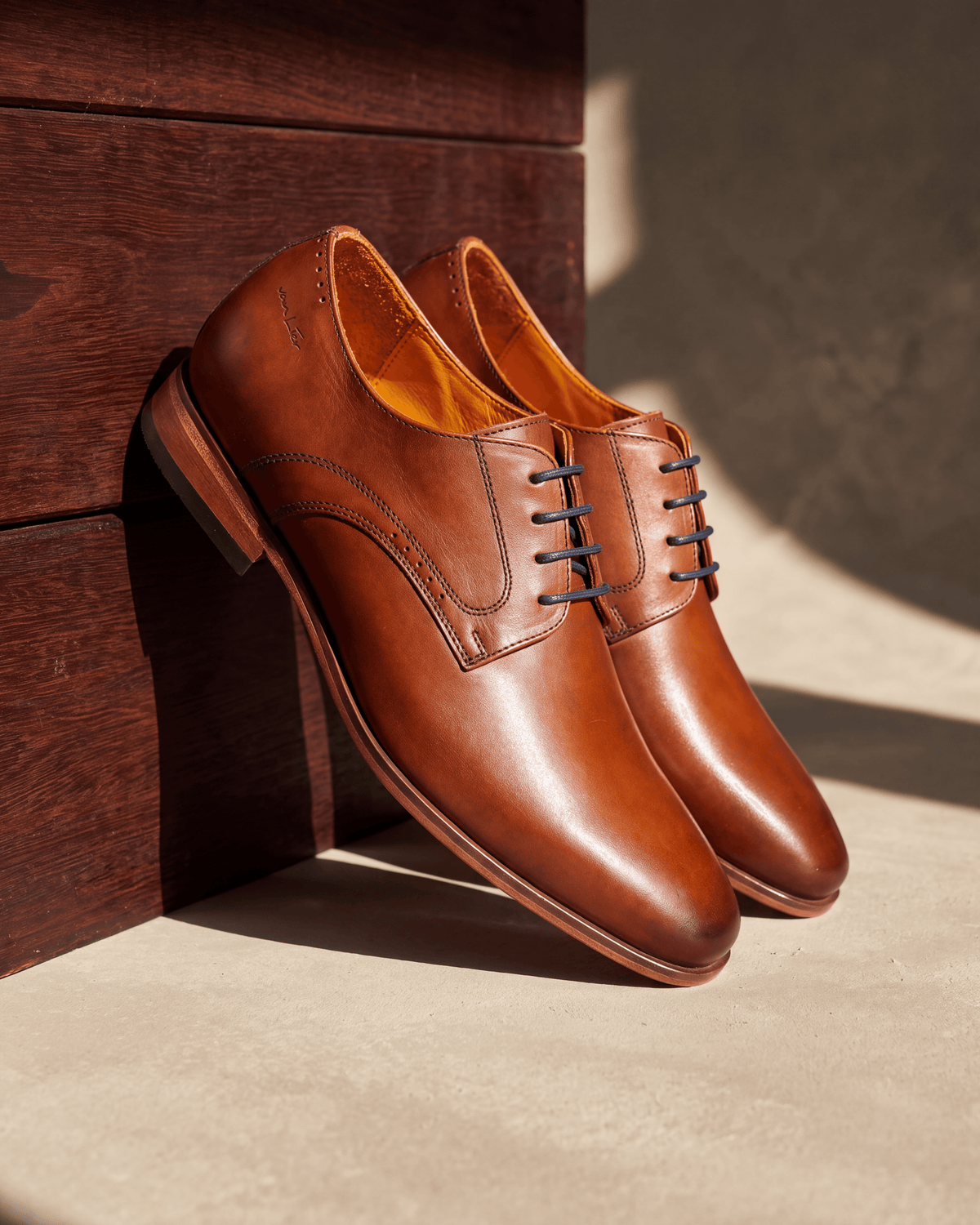 Cognac gladleren Rhodes veterschoen – het paar op hout en pleisterwerk