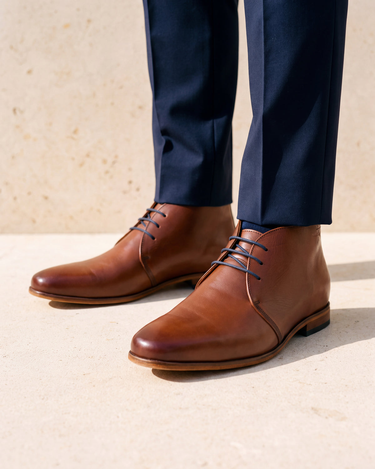 Cognac gladleren Rhodes halfhoge veterschoen – close-up van het paar op een kalkstenen vloer