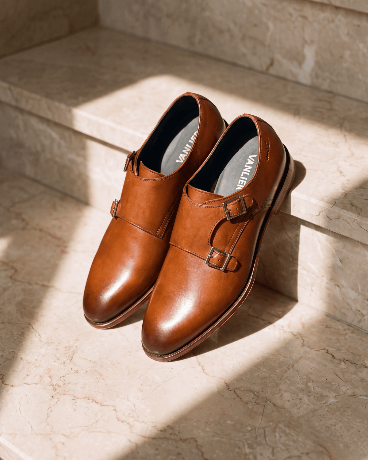 Cognac gladleren Madison gespschoen – close-up op warm marmer