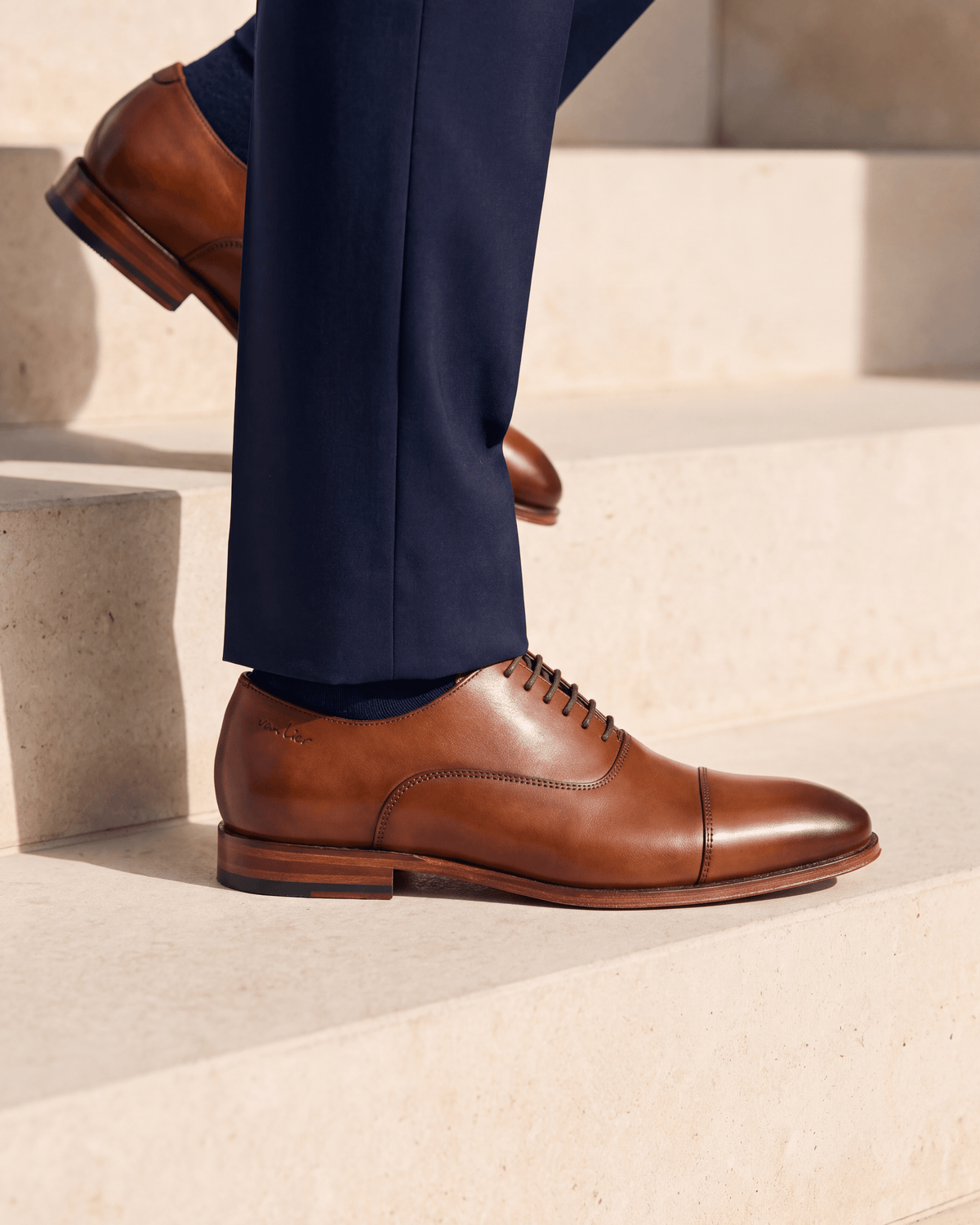 Cognac gladleren Madison veterschoen – close-up van het paar op kalksteen