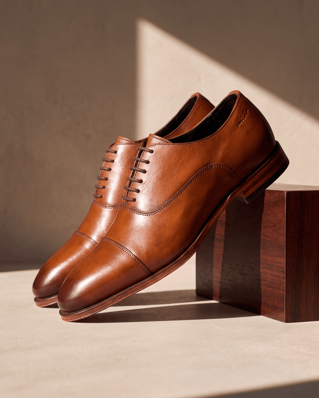 Cognac gladleren Madison veterschoen – detail op hout en pleisterwerk