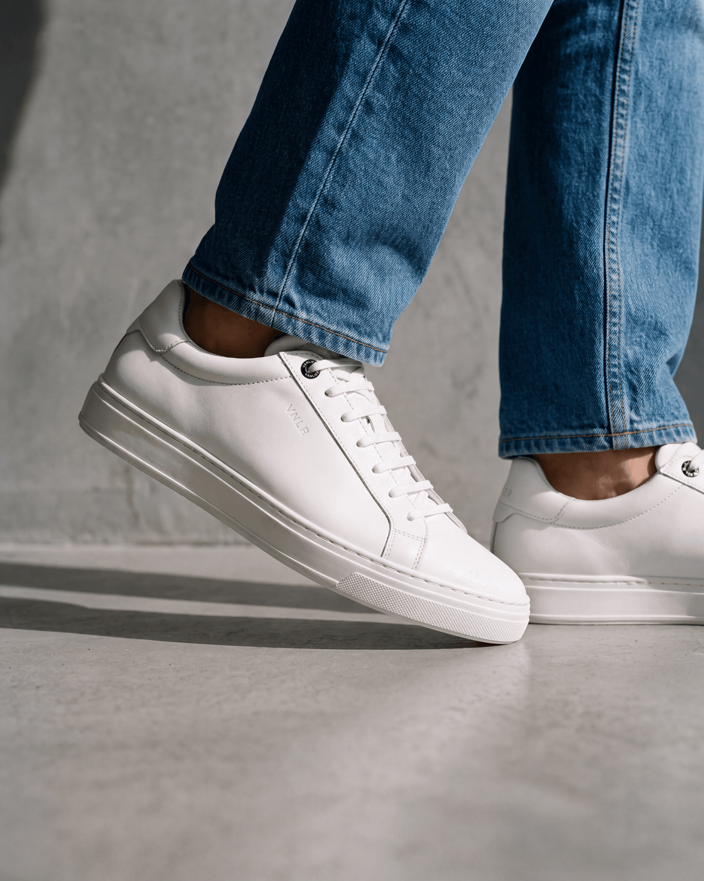 Wit gladleren Barossa sneaker – close-up van het paar op een ruwe vloer