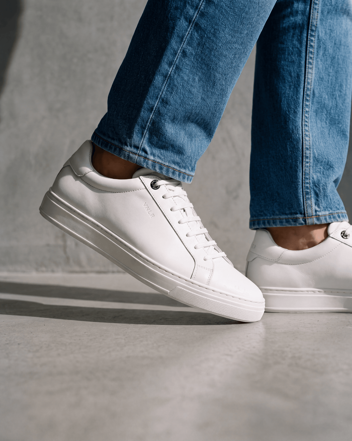 Wit gladleren Barossa sneaker – close-up van het paar op een ruwe vloer