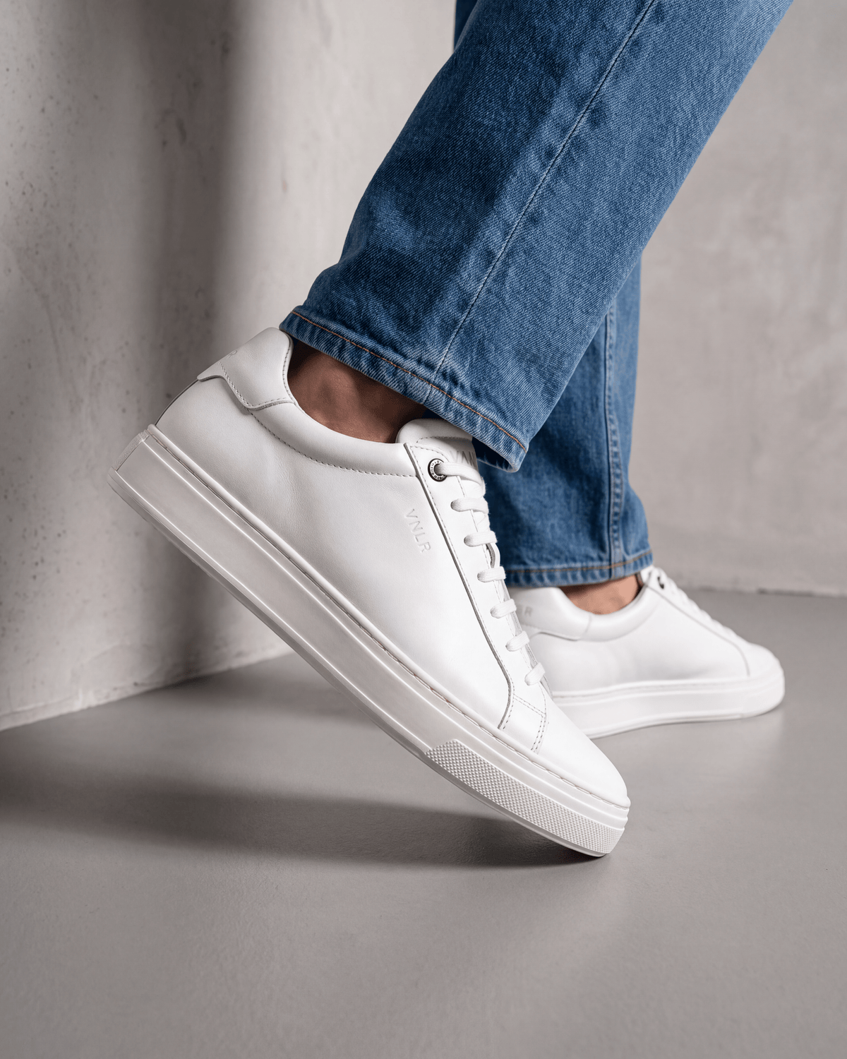 Wit gladleren Barossa sneaker – close-up van het paar op beton in een atelier