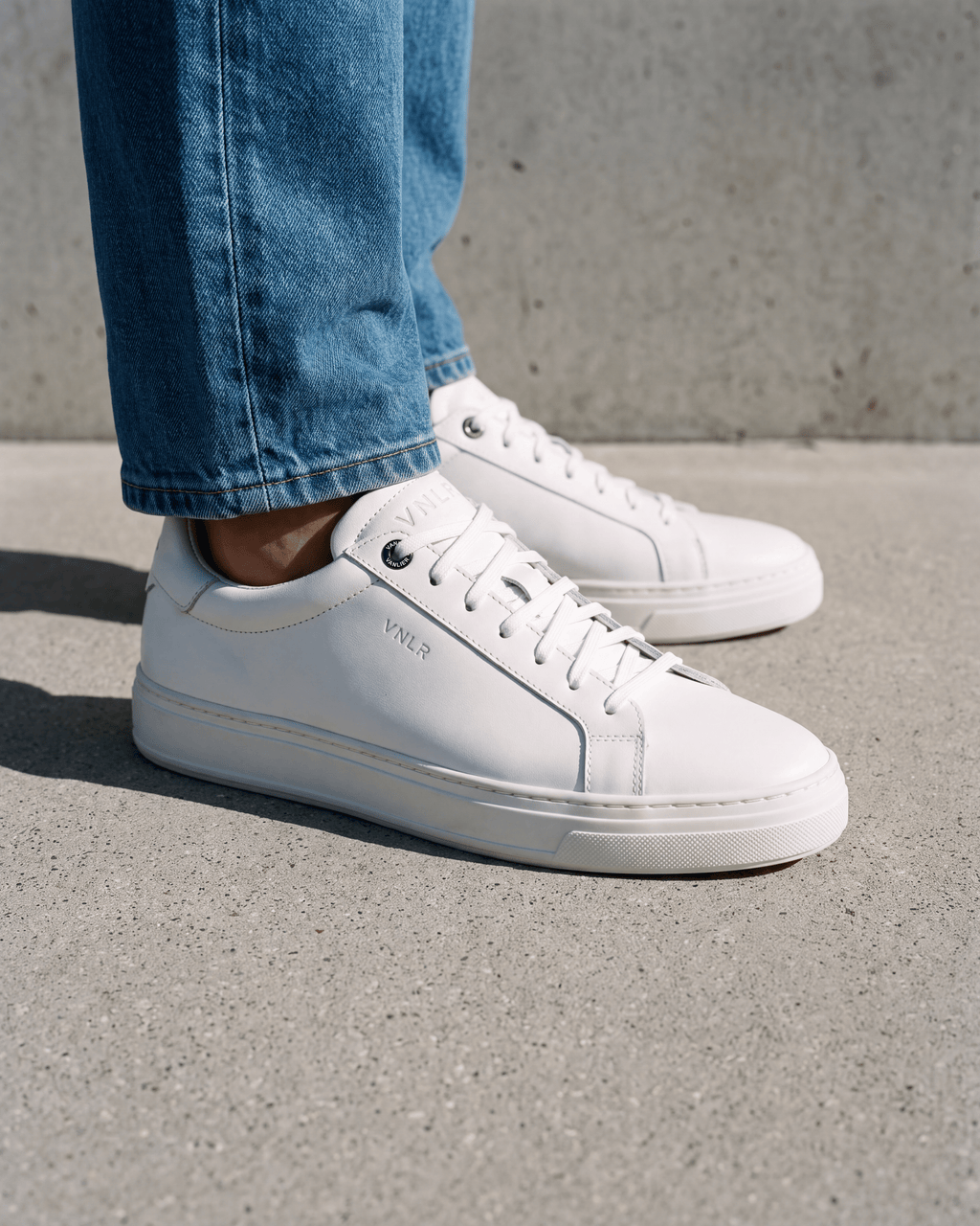 Wit gladleren Barossa sneaker – close-up van het paar op een ruwe vloer