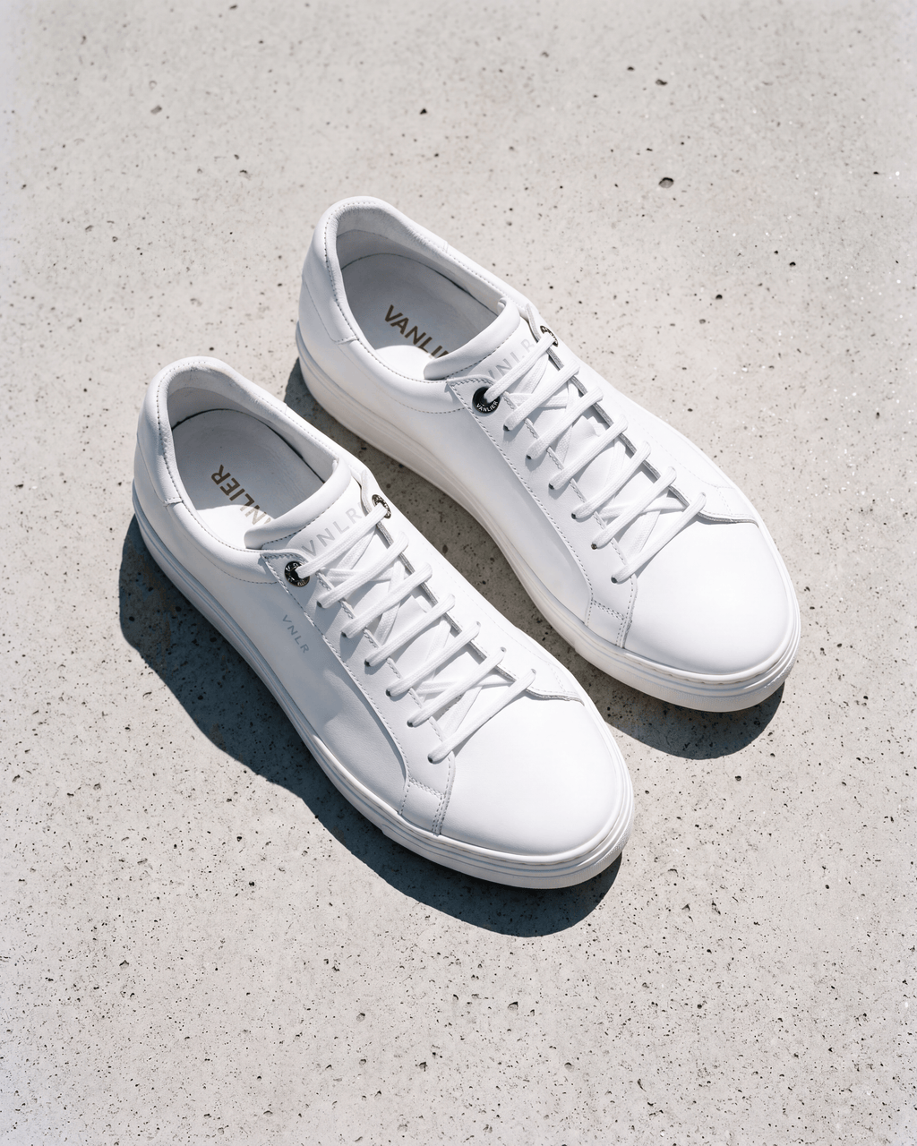 Wit gladleren Barossa sneaker – close-up van het paar in een atelier