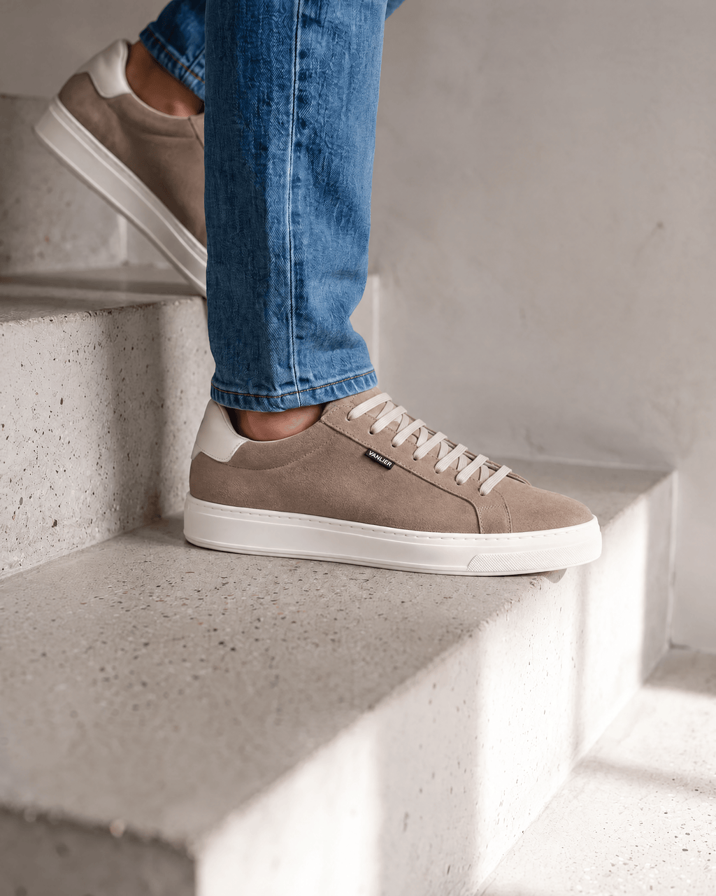 Taupe suède Barossa sneaker – close-up van het paar op beton in een atelier