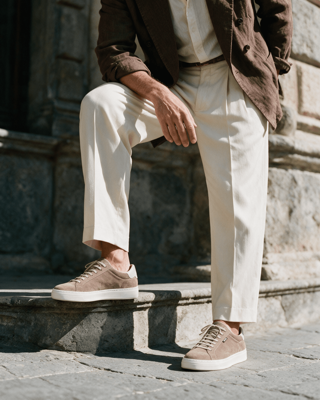 Taupe suède Barossa sneaker – gedragen, met een voet op een sokkel