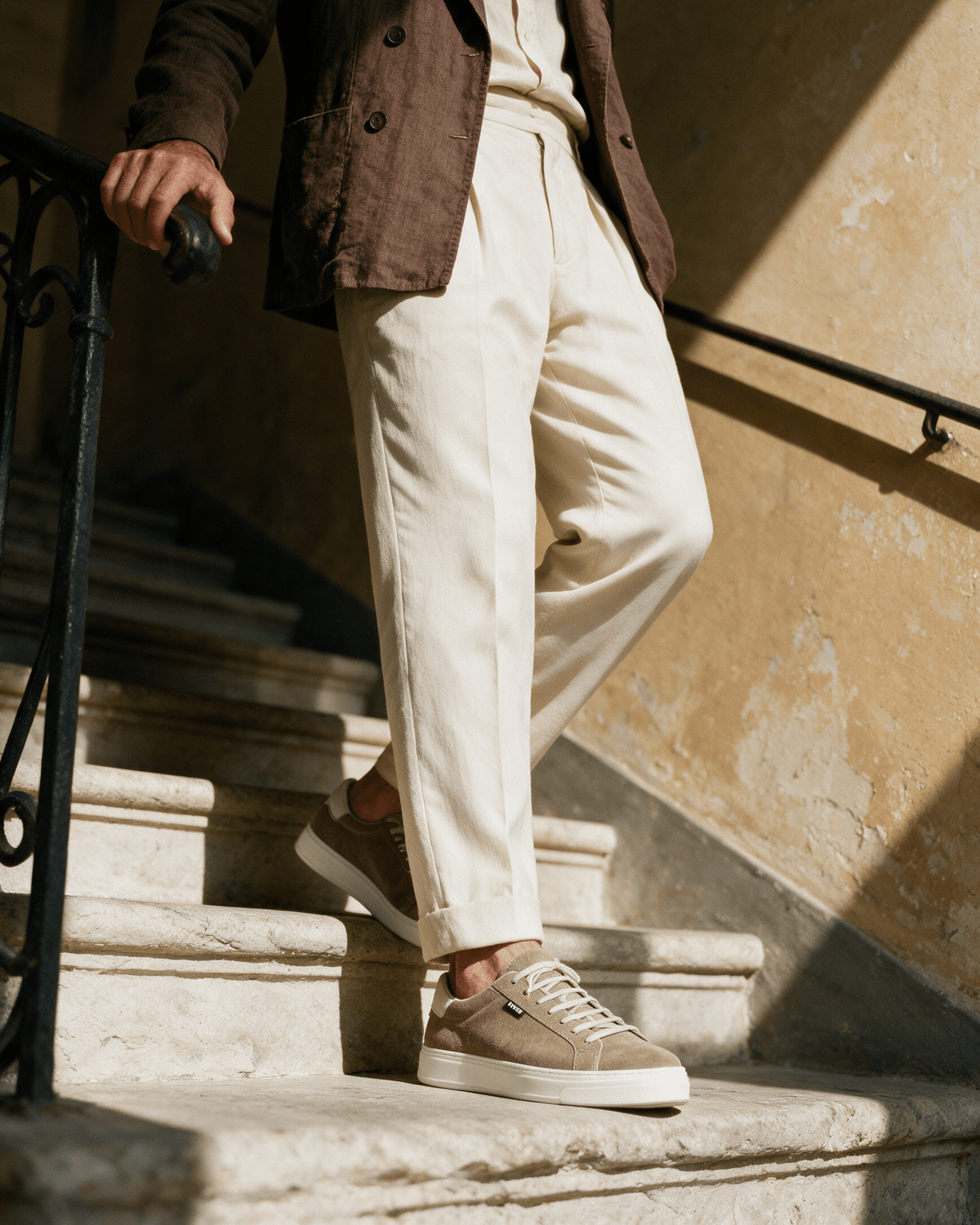 Taupe suède Barossa sneaker – gedragen, pauzerend op een trap
