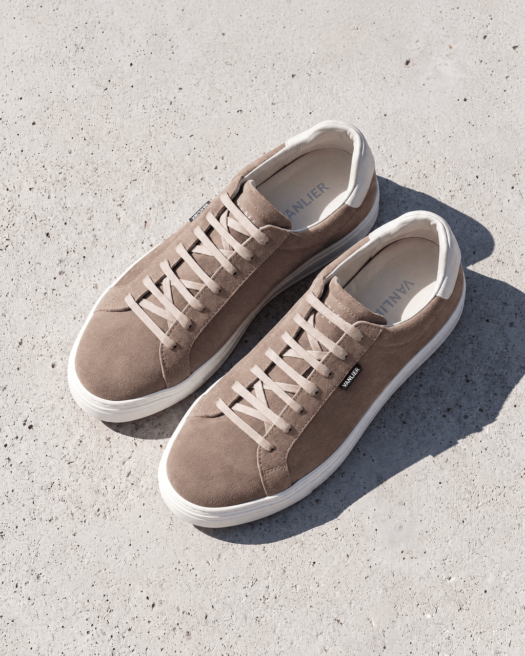Taupe suède Barossa sneaker – het paar op ruw beton